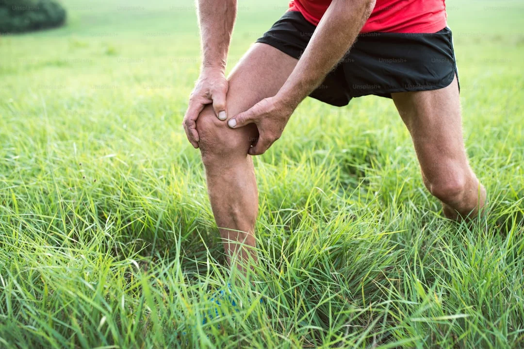 Triathlète débutant qui se tient le genou pour illustrer les blessures courantes en triathlon