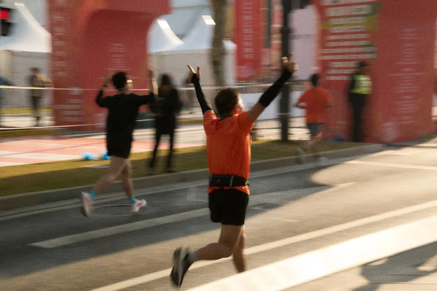 Runner bras levés franchissant la ligne d'arrivée d'un marathon