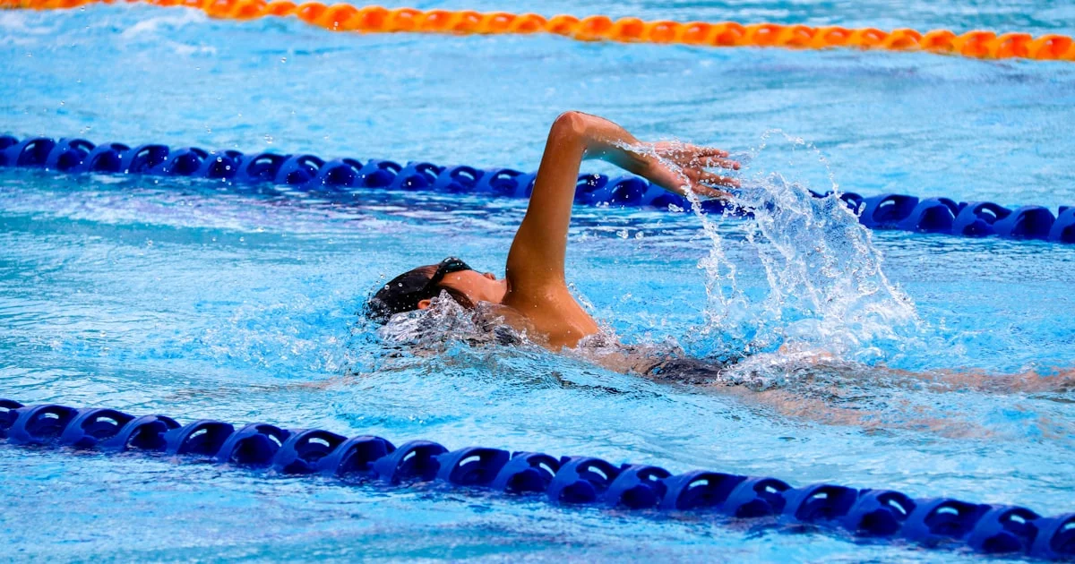 Nageur en crawl au moment de la rotation de la tête pour inspirer pendant une séance en piscine