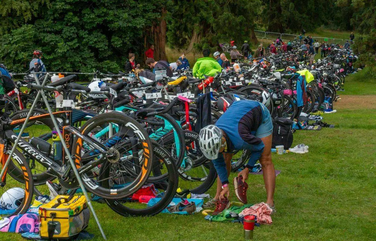 Zone de transition d'un triathlon avec vélos alignés dans le parc